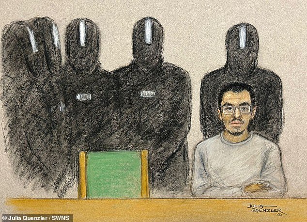 El conspirador de la bomba de la arena del Manchester, rodeado por cinco guardias en el equipo antidisturbios cuando aparece en la corte a través de un video de prisión en la corte en la corte.