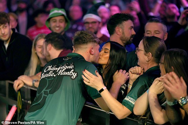 Revelado: La novia de la estrella de los dardos asiste a su eliminatoria de octavos de final contra Ally Pally, y lo besa durante su paseo, después de su arrebato de enojo porque sus empleadores le negaron el permiso.