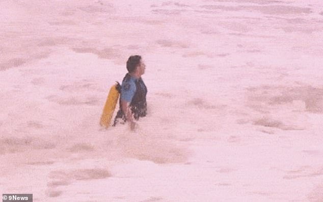 105144205-15425777-A_police_officer_is_seen_running_into_the_giant_swell_at_Coogee_-a-21_17672198785.jpeg