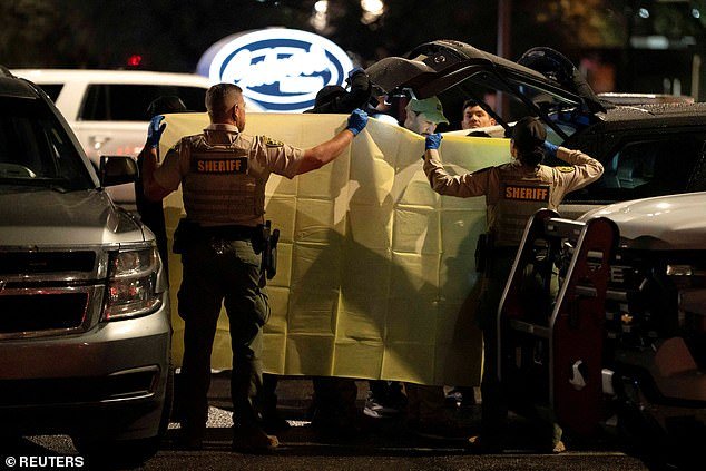 La policía de Nancy Guthrie sostiene una sábana mientras retira artículos del Range Rover después de arrestar a un hombre durante una parada de tráfico en el estacionamiento de un restaurante.