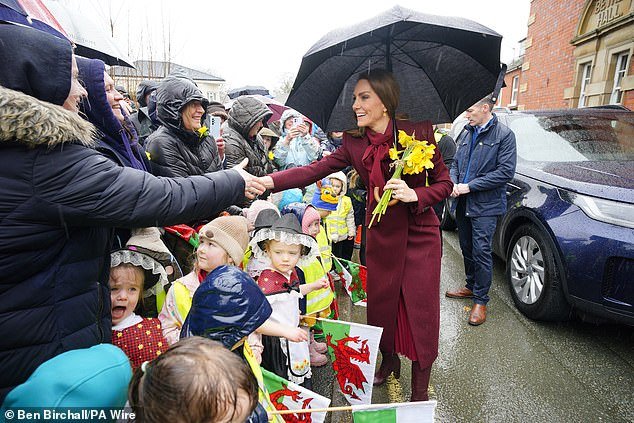 William y Kate reciben una lluvia de narcisos mientras la multitud desafía la lluvia para verlos en su visita a Gales antes del Día de San David.