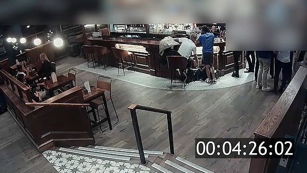 En ese momento, dos ladrones descarados registran tranquilamente las bolsas de los clientes del bar que se encuentran cerca y charlan.