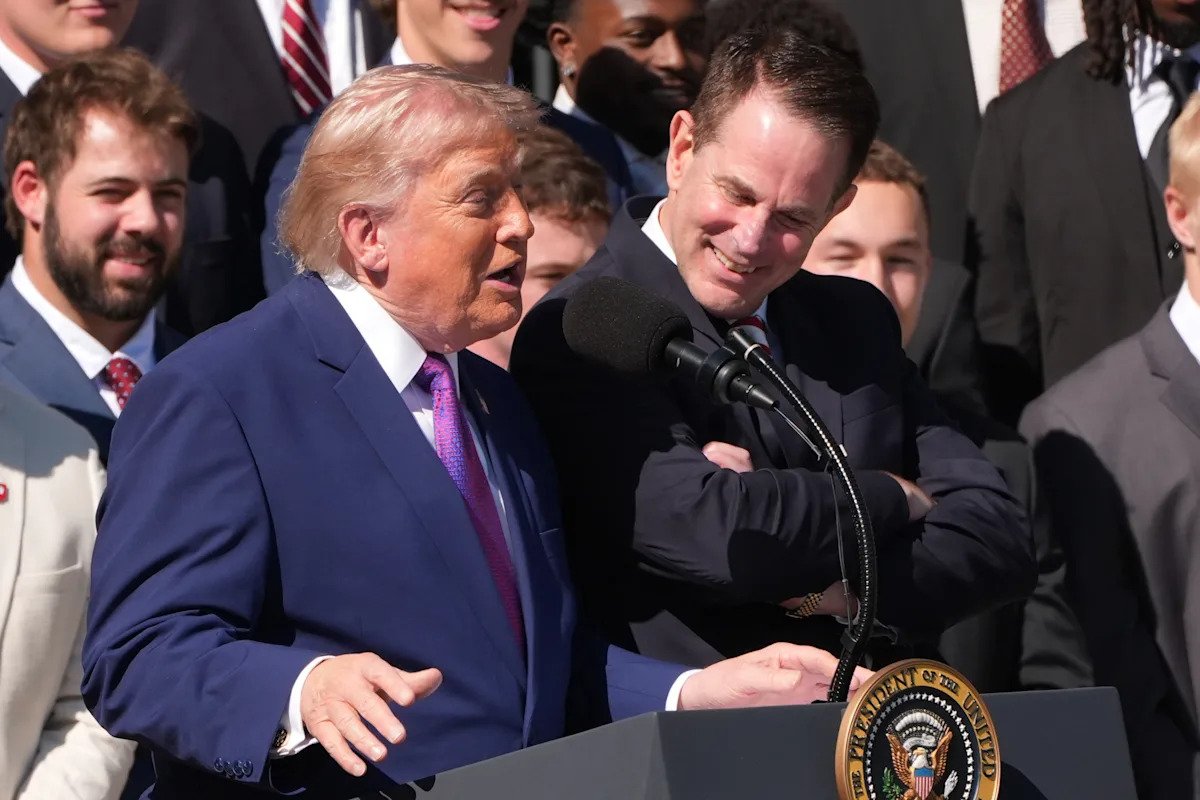 El presidente Trump busca en el escenario a Curt Cignetti, quien está junto a él en honor al equipo de fútbol de Indiana en la Casa Blanca.